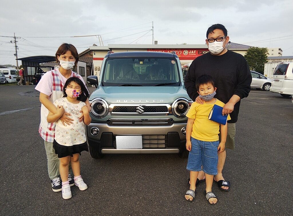 画像：車を挟んで立つ4人の親子