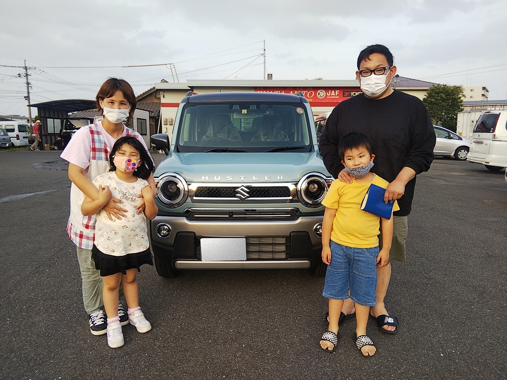 画像：車を挟んで立つ4人の親子