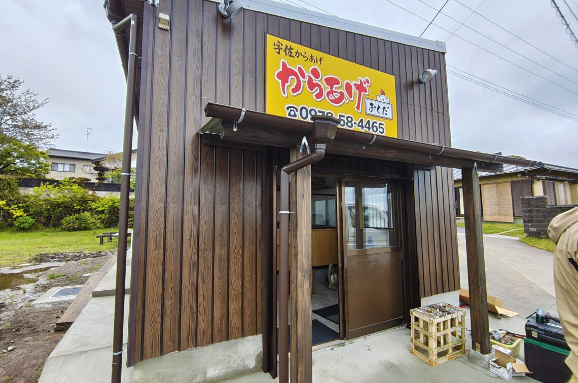 「からあげ おくだ」の店舗外観。白を基調としたプレハブ型の店舗に、青色で「からあげ おくだ」と書かれた清潔感のある看板が掲げられている。